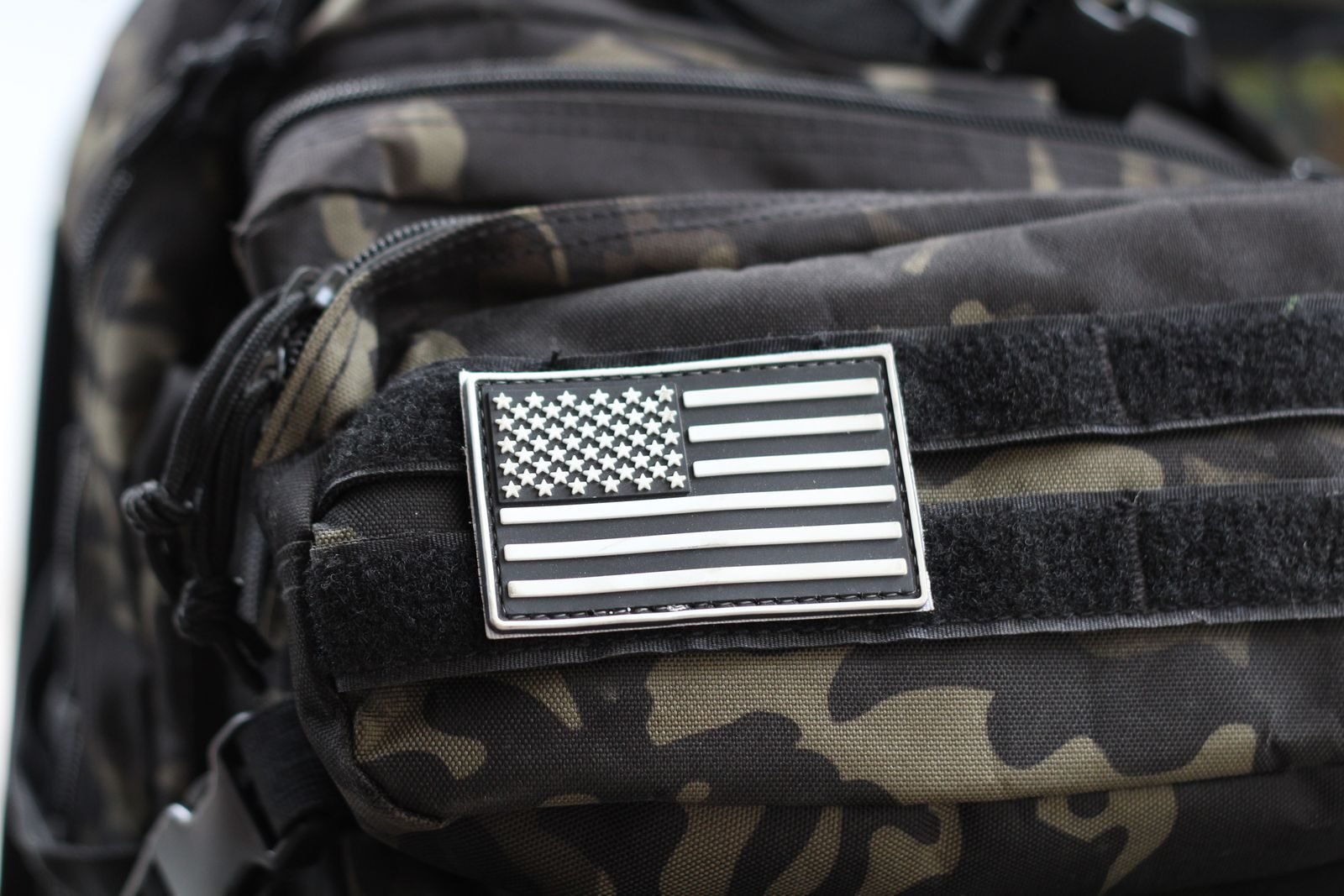 Close-up of a camouflage backpack with a PVC patch