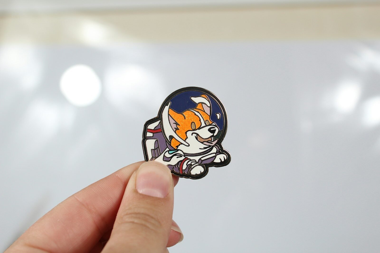 Hand holding a small enamel pin